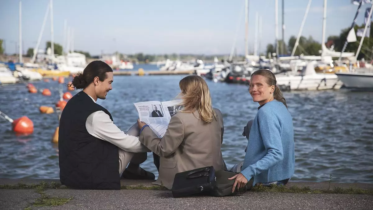 Kolme ihmistä työskentelee satamassa