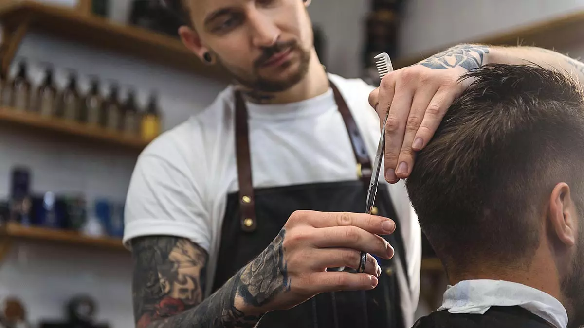 Barber cuts cutomer's hair