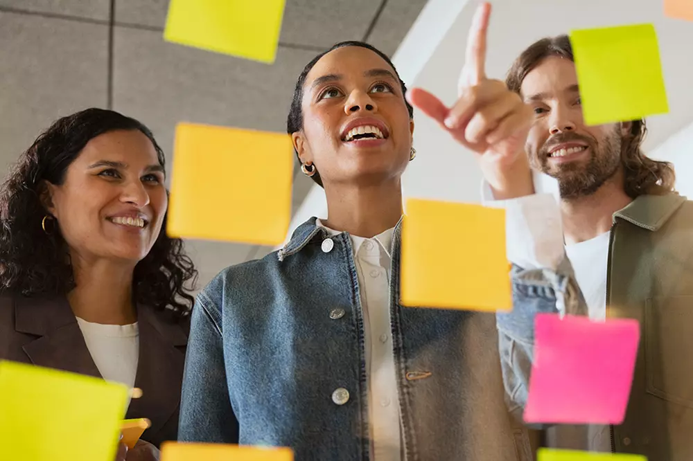 Luovan alan yrityksessä ihmiset katsomassa post-it -lappuja
