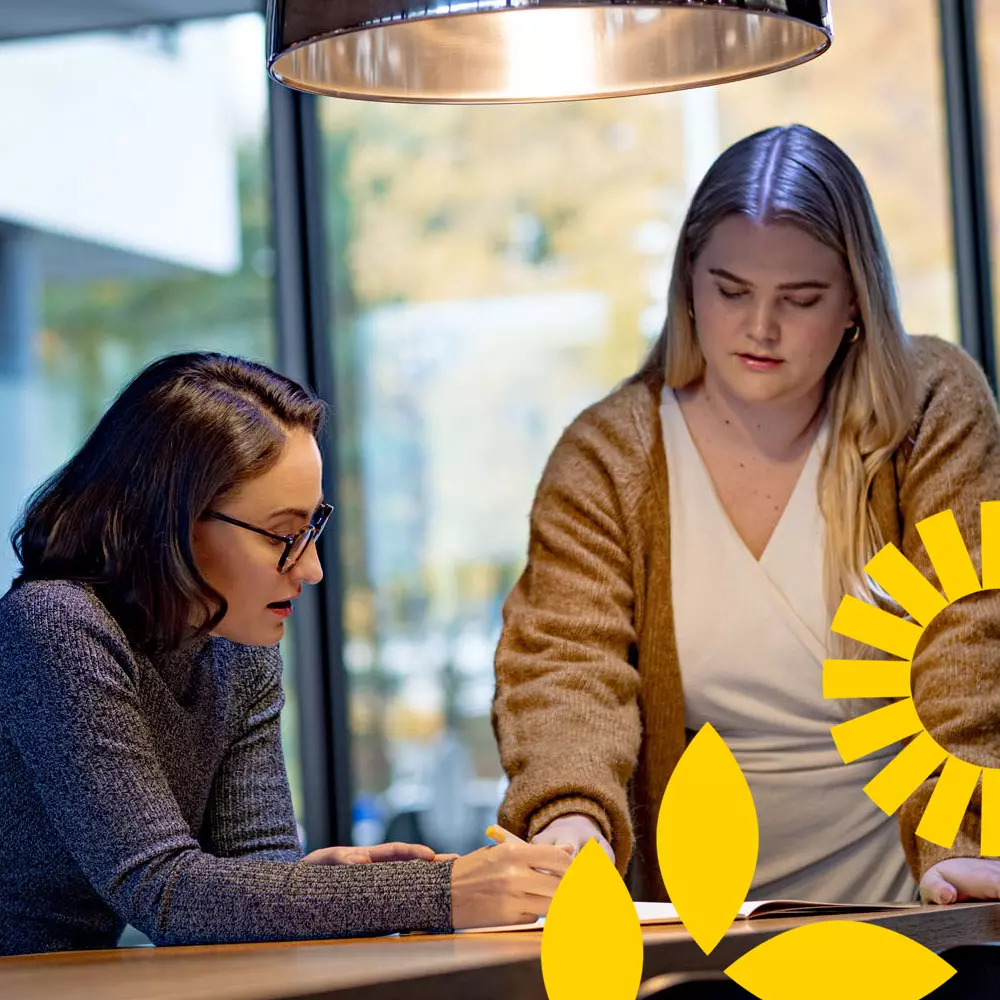 Två kvinnor pratar på kontoret