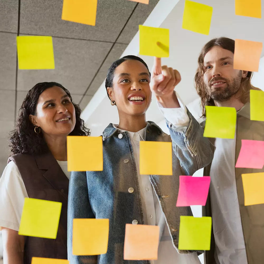 Tre personer tittar på post-it-lappar