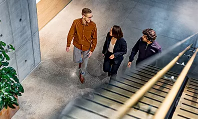 kolme henkiloa keskustelee kävellessään