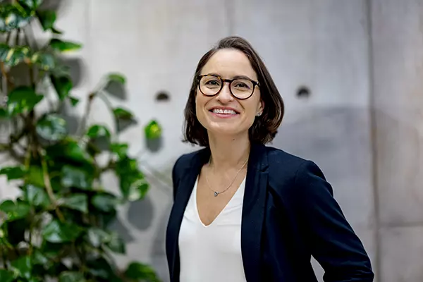 Nainen hymyilee toimistolla