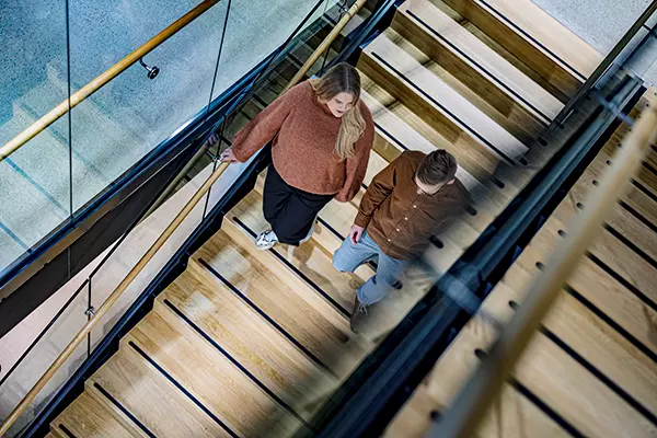 Kaksi henkilöä kävelee alas portaita