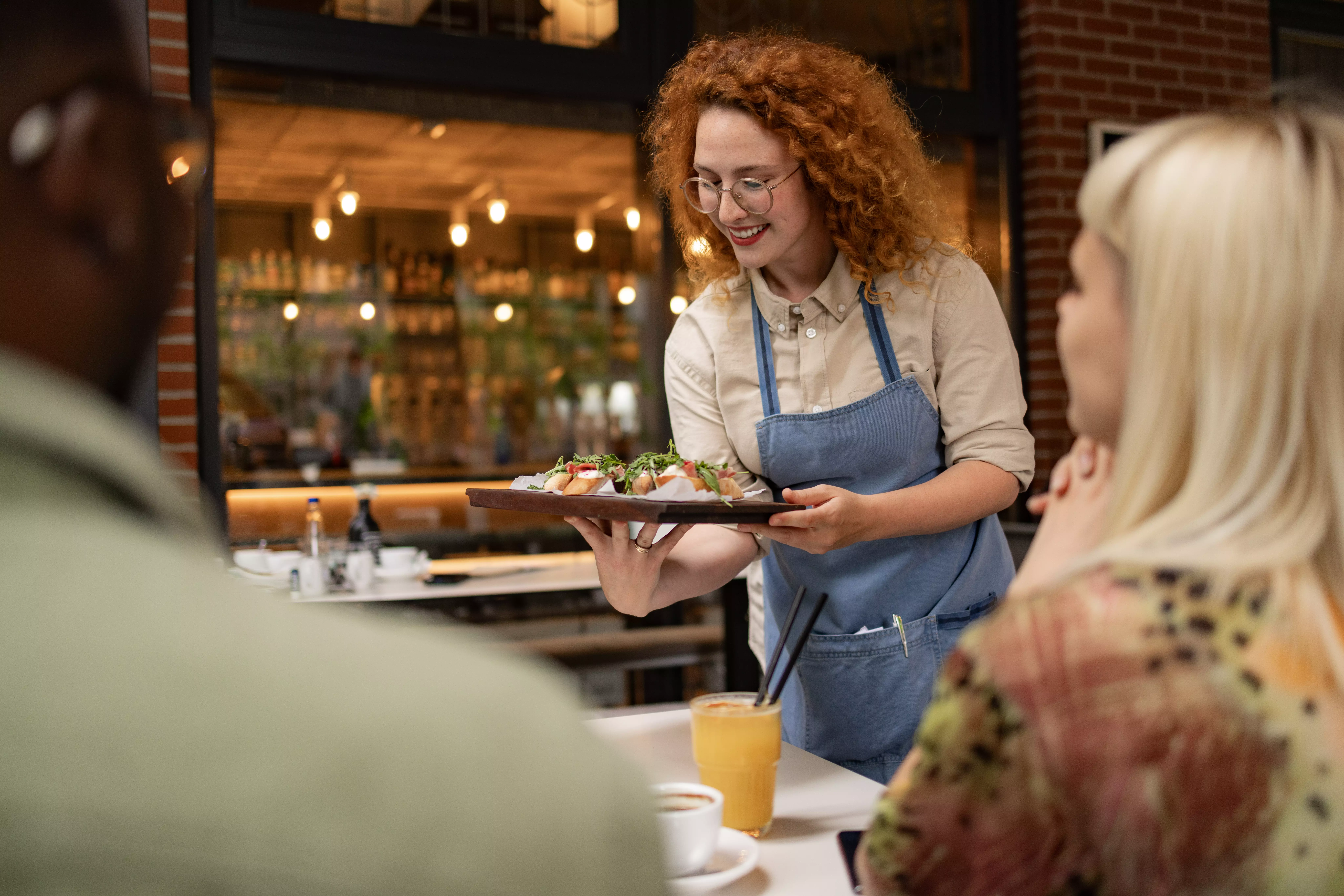 A picture of a waitress serving food in a restaurant