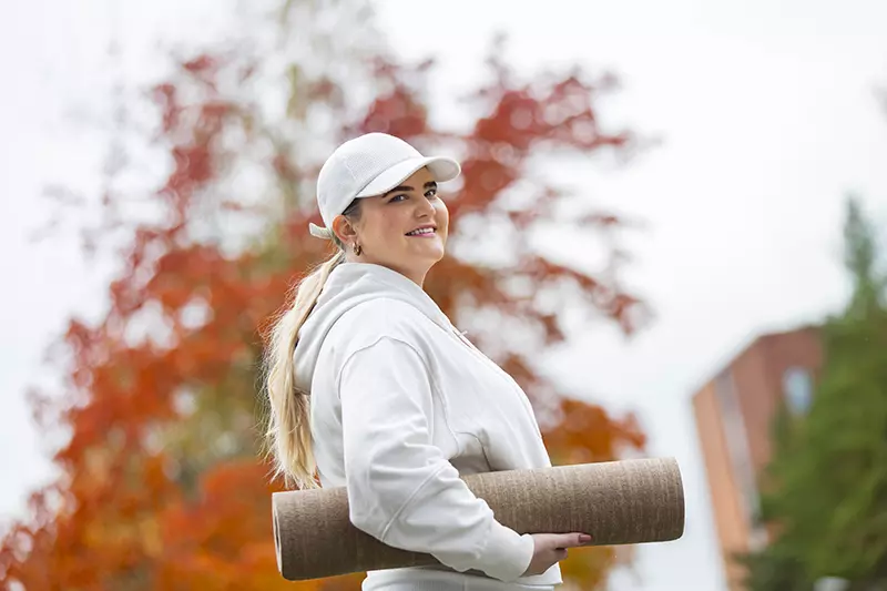 A woman smiles in work attire