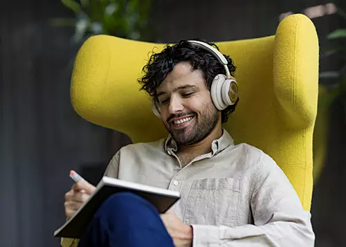 A man is sitting with headphones on