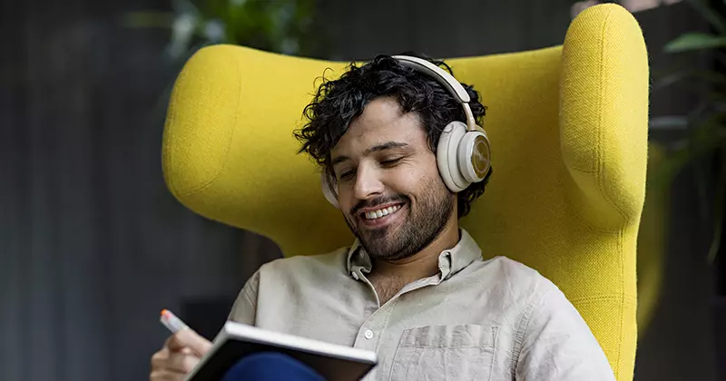 Mies hymyilee kuulokkeet korvilla