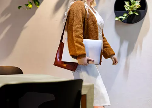 Nainen kävelee kannettava kädessä