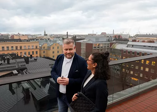 Kaksi henkilöä keskustelee kattoterassilla