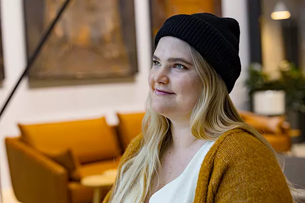 Kvinnan ler med en mössa på huvudet